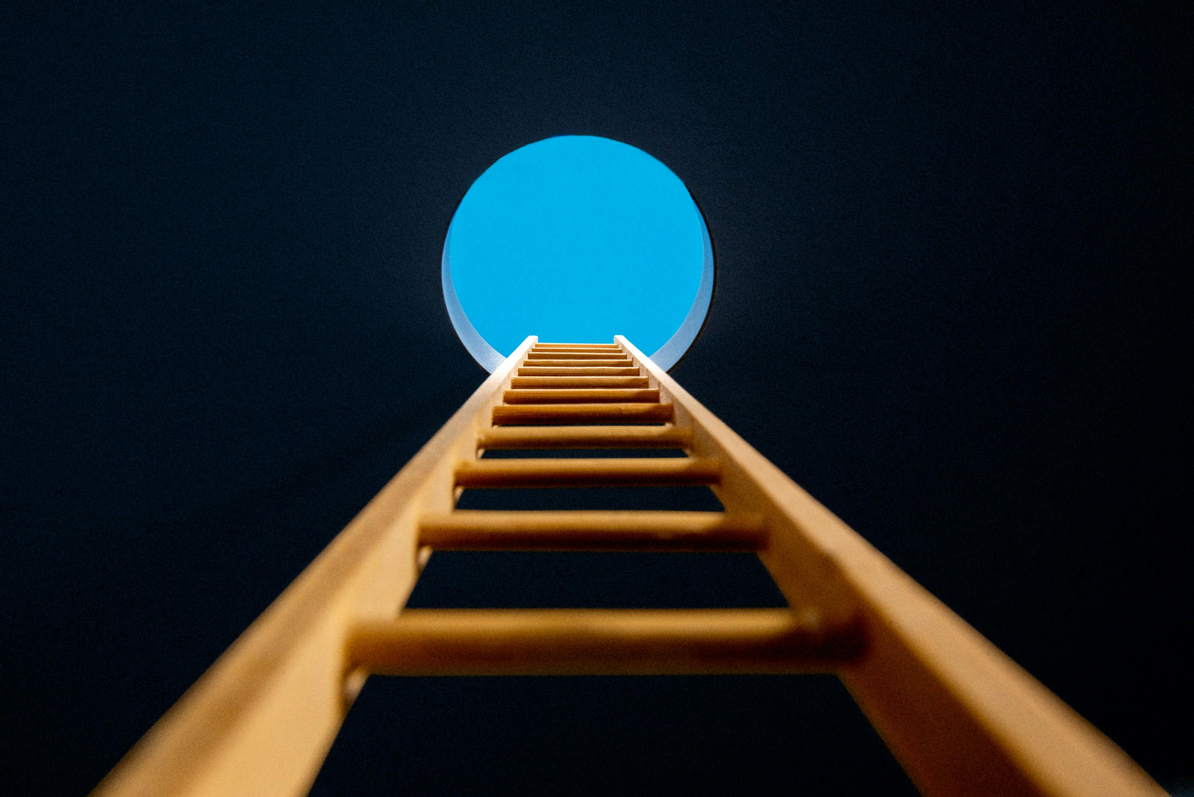 Ladder leading up to a hole showing a blue sky